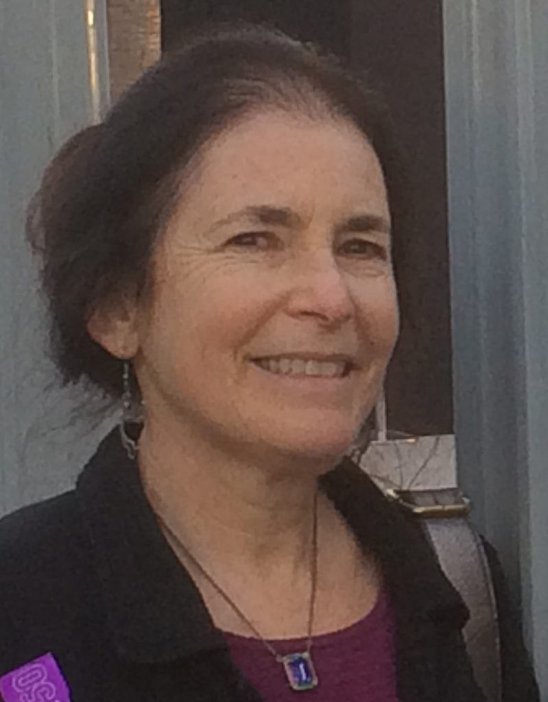 Photo of Glenna Lang, a white woman with brown hair pulled into a bun. 